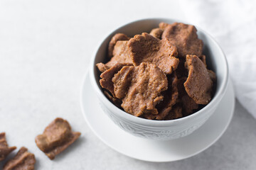Overhead view of kuli-kuli on a white plate, top view of nigerian groundnut cakes on a plate, fresh homemade nigerian kulikuli on a ceramic plate