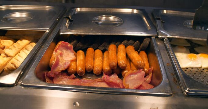 Sausage  bacon egg breakfast food at canteen buffet hot containers
