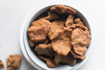 Overhead view of kuli-kuli on a white plate, top view of nigerian groundnut cakes on a plate, fresh homemade nigerian kulikuli on a ceramic plate