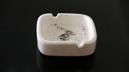 top view of metal ashtray on rattan woven table