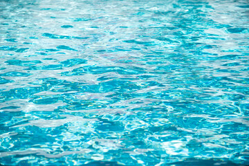 Water background, ripple waves. Blue swiming pool pattern. Sea surface. Water in swimming pool with sun reflection. Banner with copy space.
