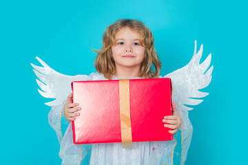 Kid boy angel with gift box present. Christmas kids. Little cupid angel child with wings. Studio...