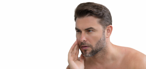 Naklejka premium Cream treatment for male face. Beauty routine. Face of a beautiful man with perfect skin. Anti-aging and wrinkle. Concept of male beauty. Skincare and cosmetics concept. Skin care. Banner, copy space.