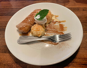 Banana wrapped on flour tortilla, dip fried and topped with cinnamon sugar served with vanilla ice-cream.