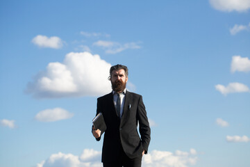 Business man on sky. Business man is thinking about something with pencil. Young thoughtful bearded man think.