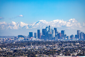 View over Los Angeles Skyline in California with snow covered mountains in the background. Visible...