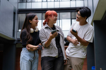 Group of cheerful diverse students using smartphones, enjoying break time at university campus, sharing funny content and social media posts