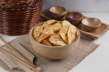 Indonesian banana chips on a wooden bowl with a traditional property theme photographed with studio light