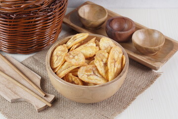 Indonesian banana chips on a wooden bowl with a traditional property theme photographed with studio light