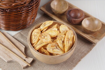 Indonesian banana chips on a wooden bowl with a traditional property theme photographed with studio light