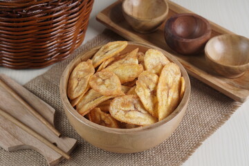 Indonesian banana chips on a wooden bowl with a traditional property theme photographed with studio light