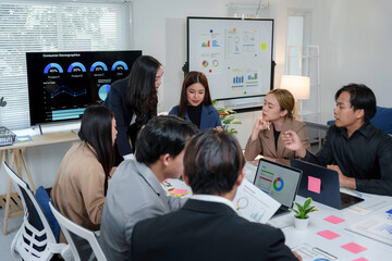 Business colleagues discussing marketing data displayed on a laptop screen during a productive meeting in a modern office