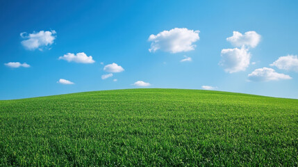 Obraz premium vibrant green hill under clear blue sky with fluffy white clouds creates serene landscape. This picturesque scene evokes feelings of tranquility and peace