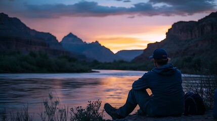 Person Silhouetted Against Sunset Over Canyon River
