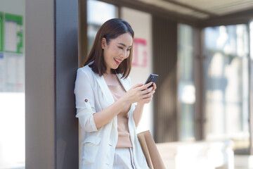 Happy businesswoman using mobile phone app for online shopping, banking or checking social media