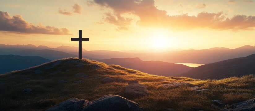 Serene sunset view of mountain range with cross on hill and orange sky, reflecting calmness and tranquility
