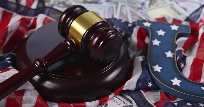 Legal gavel is placed on an American flag with currency in background, highlighting justice themes