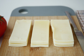 Deliciously Sliced Cheese Displayed Beautifully on a Wooden Cutting Board