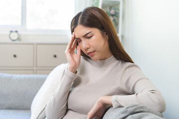 Depressed anxiety asian young woman frustrated hand on head, touching her temples, suffering stressed, sick, tired, crisis on sofa from headache, migraine pain tension problem health care concept.