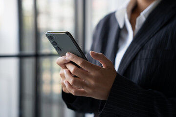 Asian Business woman using smart phone spending time checking news social media