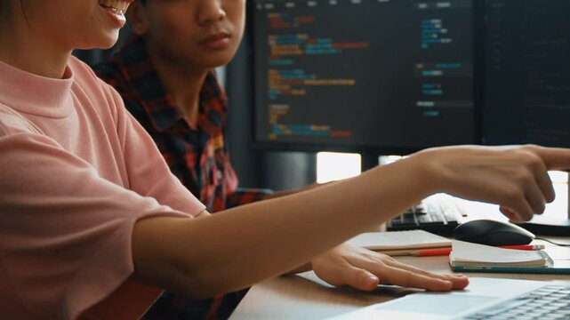 Slow motion back end software developer engineer for computer programming working together on debugging writing computing code, solving complex algorithms display on monitor in office. Burgeoning