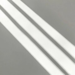  Soft light rays streaming across a smooth white surface, creating a serene and abstract background perfect for design, presentations, or creative projects.  