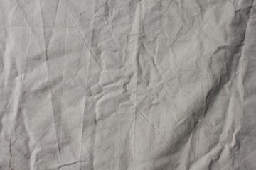 Wrinkled Beige Canvas Fabric Background with Natural Folds and Texture for Design and Textiles