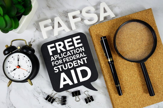 FAFSA - Free Aplication for Federal Student Aid acronym with alarm clock and magnifying glass, business concept background