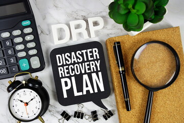 DRP - Disaster Recovery Plan acronym with calculator, alarm clock and magnifying glass, Business...