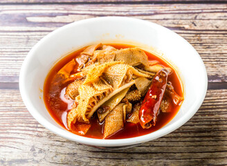 Spicy Beef Tripe and Cypress Leaves served in bowl isolated on wooden table side view of hong kong food