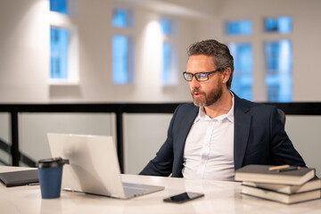 Fototapeta premium Office worker with laptop at office. Ofice employee remote working in modern office. Businessman have on line meeting. Business man using computer in office. Modern offices workplace.