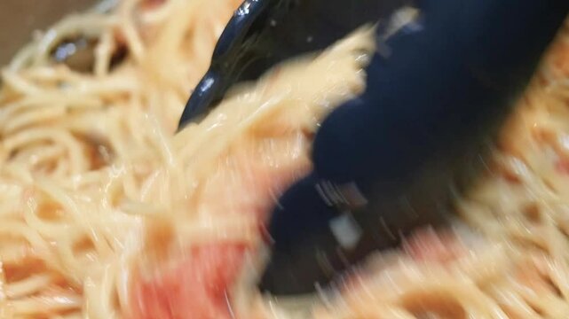 日本のパスタ料理。たらこと舞茸とスパゲッティーを混ぜてる動画。クローズアップ。