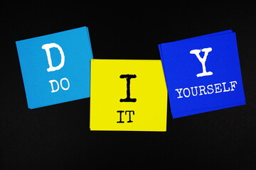DIY - Do It Yourself acronym text on sticky note on black background