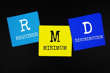 RMD - Required Minimum Distribution acronym text on sticky note on black background