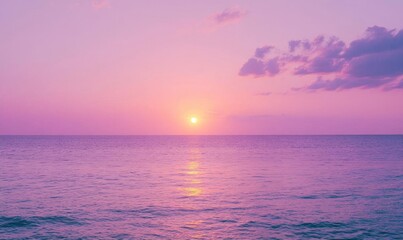 Obraz premium A serene sunset over the ocean, casting a soft purple hue on the water.