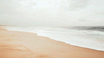 Serene beach scene with gentle waves and soft sand under a cloudy sky.