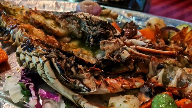 Closeup shot of Langust cuisine with various veggies and butter filled.