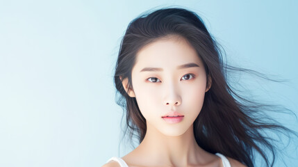 Obraz premium Portrait of smiling asian teenager girl blue background.