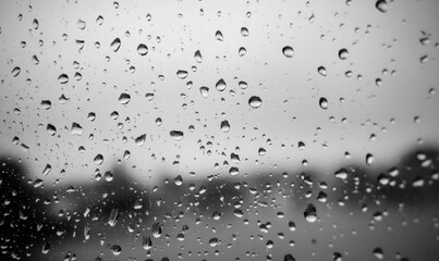 A close-up of raindrops on a window, creating a moody atmosphere.