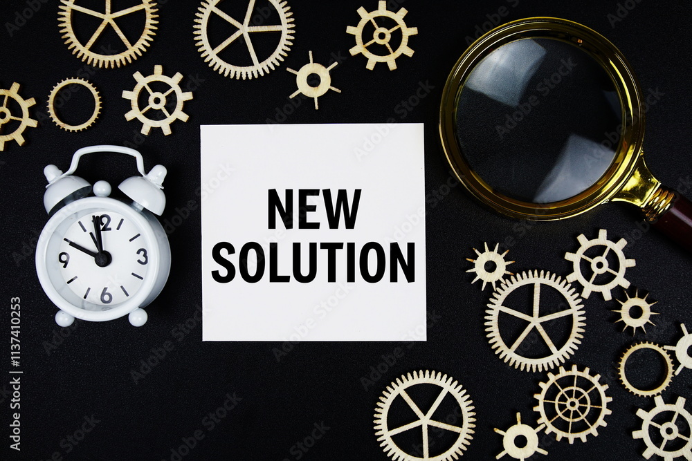 Poster new solution text message on sticky note with magnifying glass and alarm clock on black background