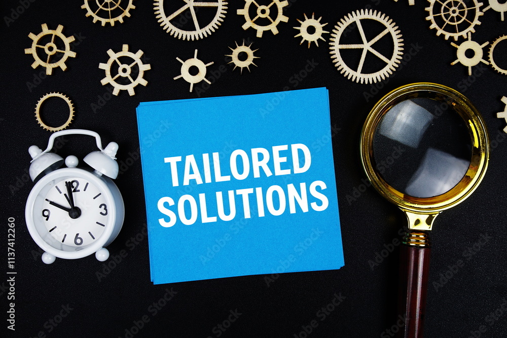 Poster tailored solutions text message on sticky note with magnifying glass and alarm clock on black backgr
