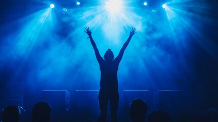 triumphant figure backlit, arms raised victory pose, glowing stage spotlight, dark audience foreground, atmospheric blue lighting, professional event scene, powerful celebration moment