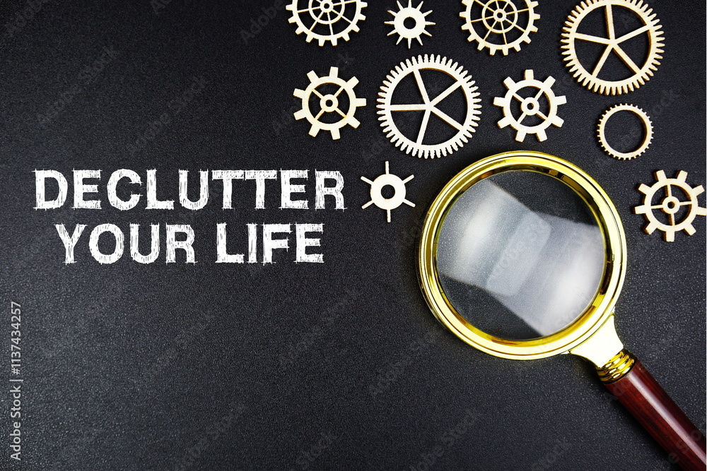 Poster declutter your life text message with magnifying glass on black background
