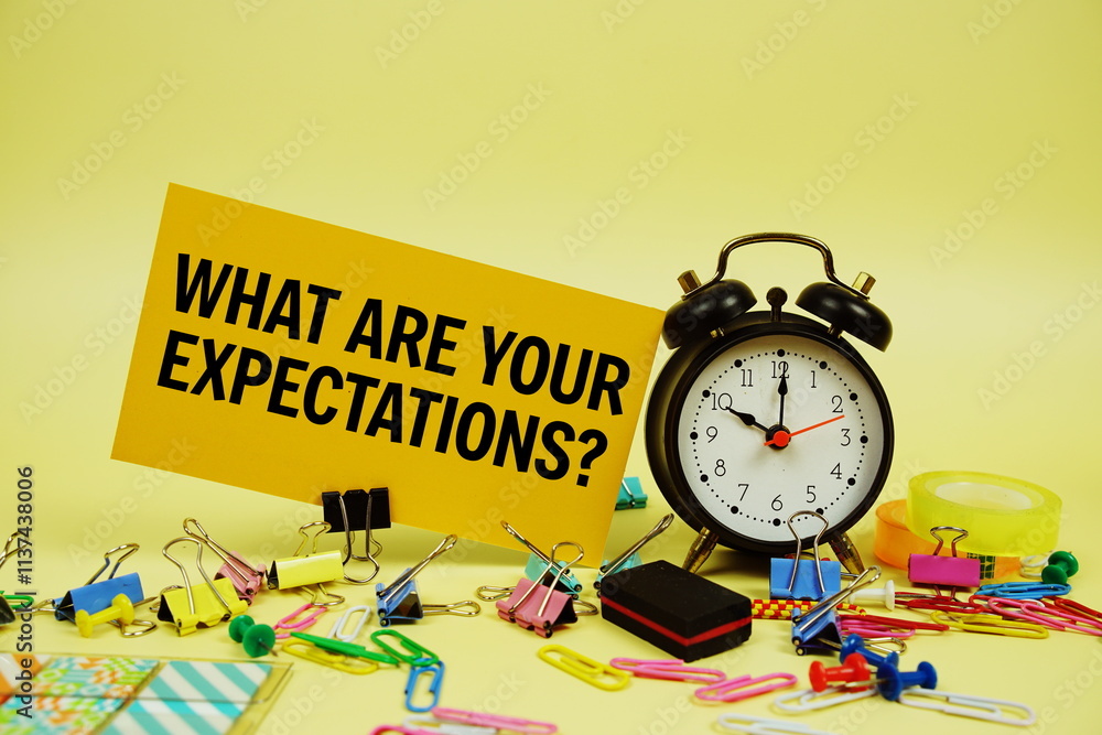 Poster what are your expectations? text on paper card with alarm clock and stationery on yellow background