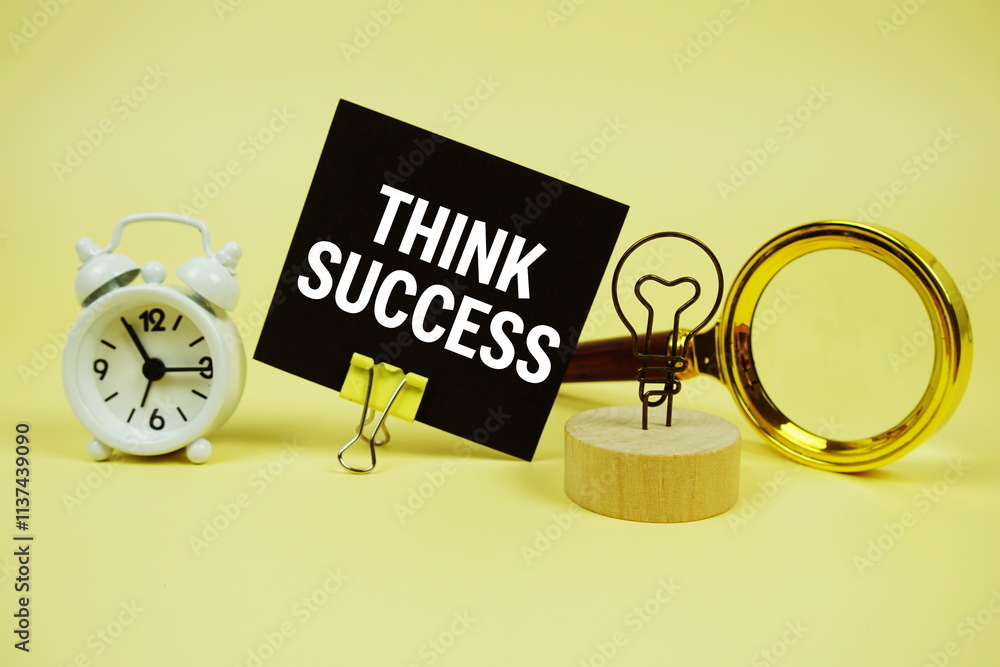Poster think success text message on sticky note with magnifying glass and alarm clock on yellow background