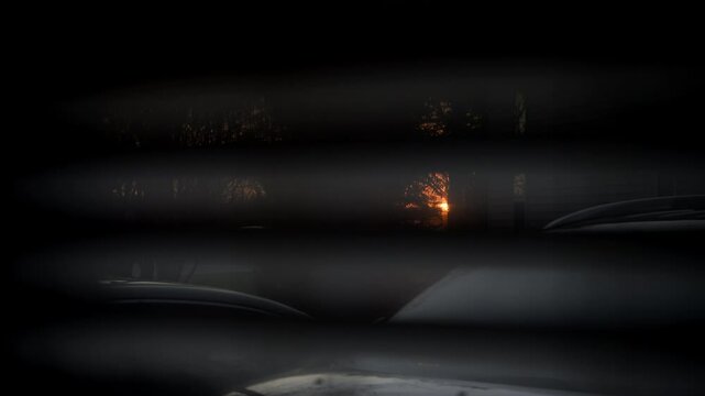 Looking at sunset through window closed by blinds