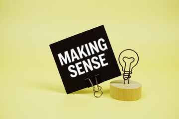 Making Sense text message on sticky note on yellow background