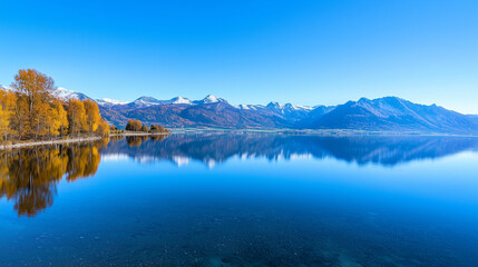 Naklejka premium Serene Mountain Reflections: A panoramic view of a tranquil mountain lake, mirroring the majestic peaks in its crystal-clear waters.