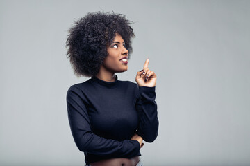 Young woman having an idea pointing finger up