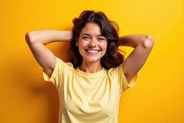 Fototapeta premium Bright and Cheerful Young Woman Smiling in Yellow Shirt Against Yellow Background, Perfect for Marketing and Advertising